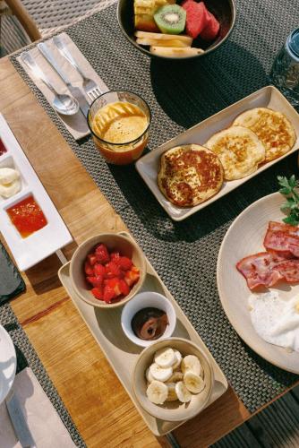 una mesa cubierta con platos de comida y tazones de fruta en Masana Algarve, en Albufeira