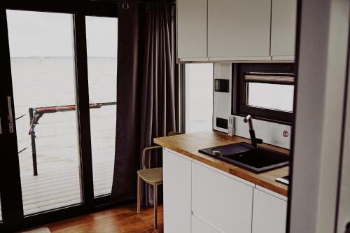 a kitchen with a counter with a sink and a window at Houseboats Dollar - Plaża Nowe Guty in Nowe Guty