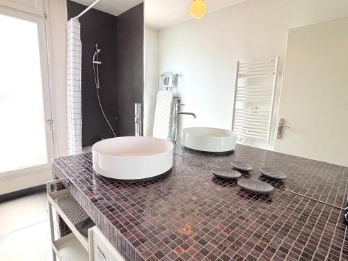 een badkamer met twee wastafels op een betegelde bar bij Le Penthouse Ampère in Nanterre