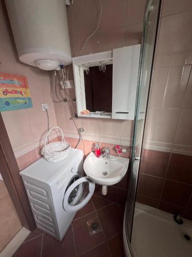 a bathroom with a washing machine and a sink at Apartments "Helios" in Njivice