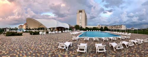 a resort with a pool and chairs and a building at Apartments Promenad in Zatoka