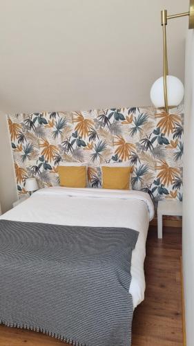 Un dormitorio con una cama con papel pintado floral. en Casa Villamor de Orbigo, 