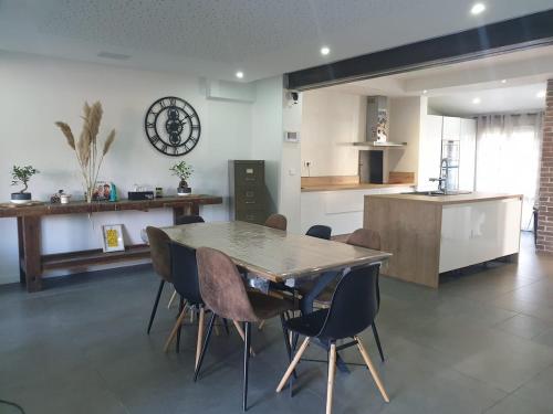 eine Küche und ein Esszimmer mit Tisch und Stühlen in der Unterkunft Belle maison au calme 200m2 in Coubron