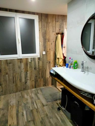 a bathroom with a sink and a mirror at Belle maison au calme 200m2 in Coubron