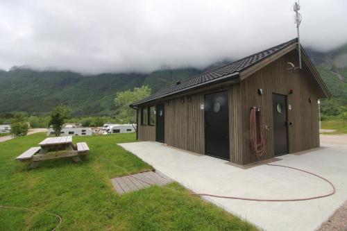 a small building with a picnic table in the grass at Storviksanden Camping in Storvik