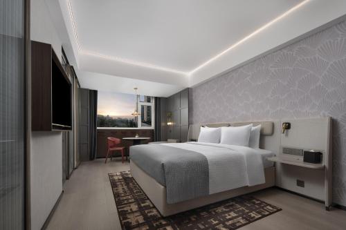 a hotel room with a bed and a table at Wanda Yue Ürümqi in Ürümqi