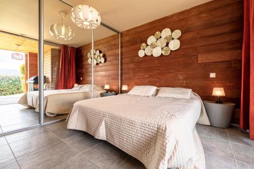 a bedroom with two beds and a mirror at Splendide appartement T3 piscine et vue mer in Grosseto-Prugna