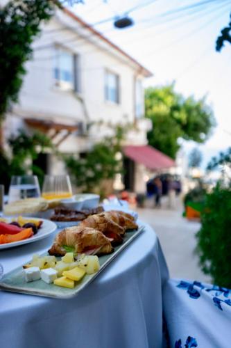 a table with a plate of food on a table at La Fe Boutique Hotel Sarande in Sarandë