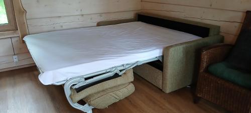 a bed sitting in a room next to a chair at Karu Rannamaja in Tahkuranna