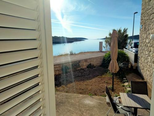 a view of a lake from a patio with an umbrella at Appartment Brani & Mira in Rukavac