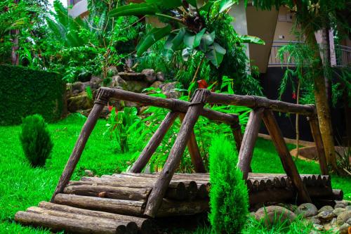 a wooden bridge in the middle of a garden at Skill forest lodge in Arusha