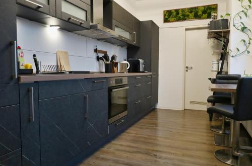a kitchen with navy blue cabinets and a stove at Ferienwohnung Buchholzer Straße 1 in Annaberg-Buchholz