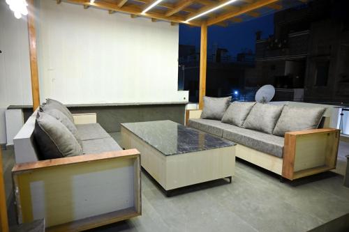 a living room with couches and a table on a balcony at Ista Inn Homestay in Amritsar