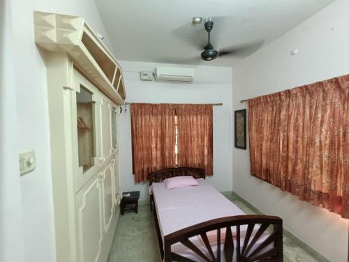 a small bedroom with a bed and a window at Thuyil Home Stay in Tirunelveli