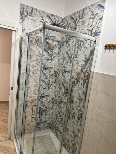 eine Dusche in einem Zimmer mit Blumentapete in der Unterkunft Attic room in Neapel