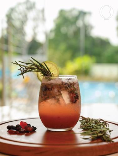 a drink sitting on a plate with a garnishment gmaxwell gmaxwell gmaxwell at Miros - Formerly Imperial Goa in Old Goa