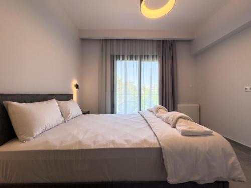 a bedroom with a large bed with a window at VILLA 8 By ProLiving Hospitality in Thessaloniki
