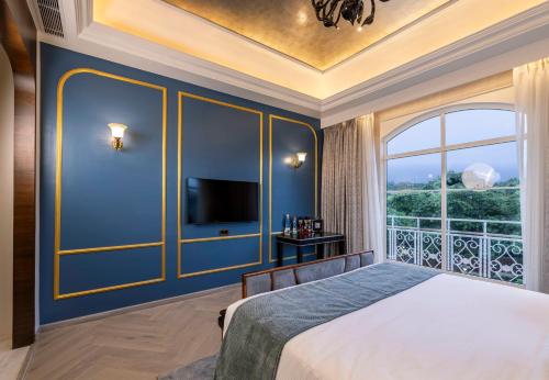 a bedroom with a bed and a large window at Miros - Formerly Imperial Goa in Old Goa