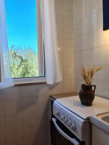a kitchen with a stove and a window at Meridiana case al mare in Mattinata