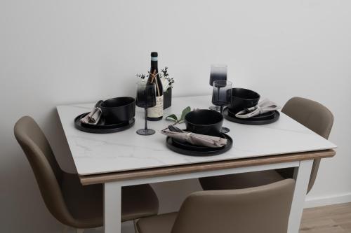 a table with black plates and wine bottles on it at Black and White Suite for Business and Holiday stays above MK Train Station, High Wi-Fi, Free Parking in Milton Keynes