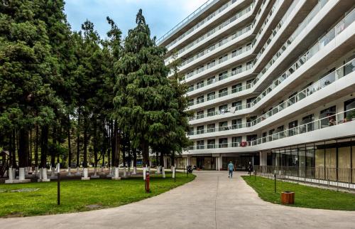 a large building with a tree in front of it at Bamboo Beach Tsikhisdziri Green Heaven in Tsikhisdziri
