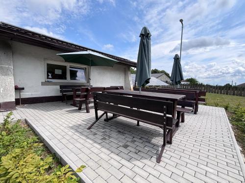 a patio with benches and a table with an umbrella at Ubytování Přimda in Přimda