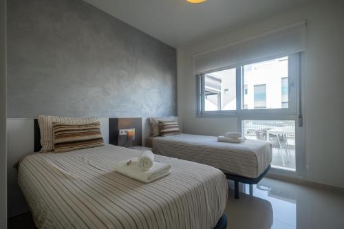 two beds in a room with a window at Mirador del Mar in Torrevieja