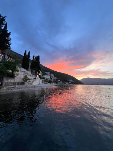 a body of water with a sunset in the background at Apartments "Helios" in Njivice