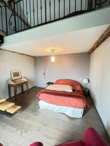 une chambre avec un lit et une table dans une pièce dans l'établissement Maison à chambois, à Gouffern en Auge