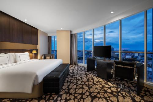 a hotel room with a large bed and a television at Melia Makassar in Makassar