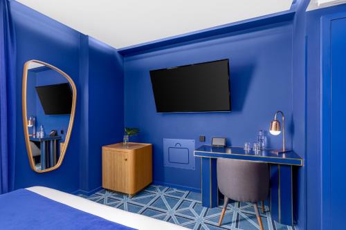 a blue room with a bed and a mirror at Room Mate Macarena, Madrid Gran Vía in Madrid