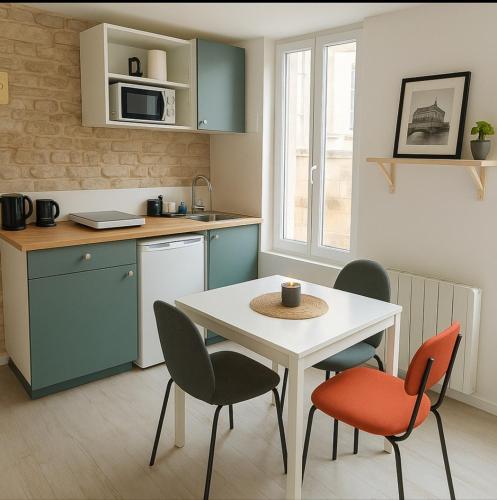 une cuisine avec une table, deux chaises, une table et une table dans l'établissement Appartement Cosy Hypercentre CAEN, à Caen