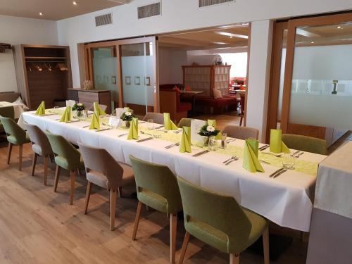 a long table in a room with green chairs at Gasthaus Hotel Sonne in Villingen-Schwenningen