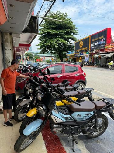 a man standing in front of a row of motorcycles at Ha Anh Homes in Ha Giang