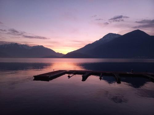 un muelle en medio de un lago al atardecer en Sunrise on the lake Musso - A59, en Musso