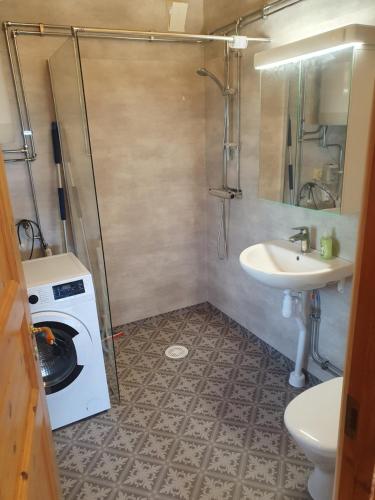 a bathroom with a washing machine and a sink at Villaberg in Arvika