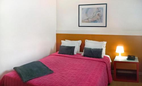 a bedroom with a bed with a red bedspread at Hotel Joao XXI in Braga