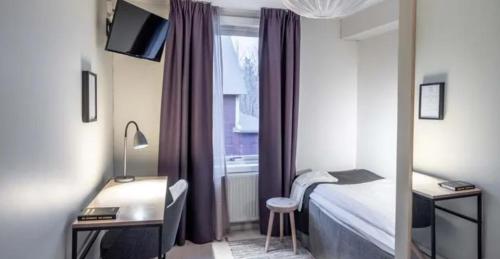 ヨックモックにあるHotel Akerlundのベッドと机と窓のある寝室