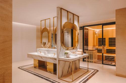 a bathroom with two sinks and two mirrors at Fairmont Mumbai in Mumbai