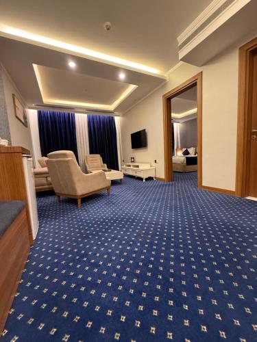 a hotel room with a waiting area with a couch and a television at Nova Sky Hotel in Erbil