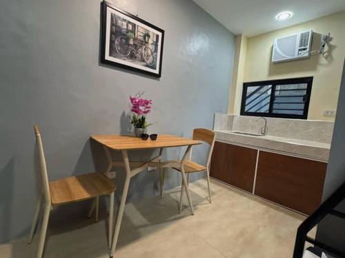 a kitchen with a table and a table and chairs at Cozy Apartment near Dahican beach in Dahikan