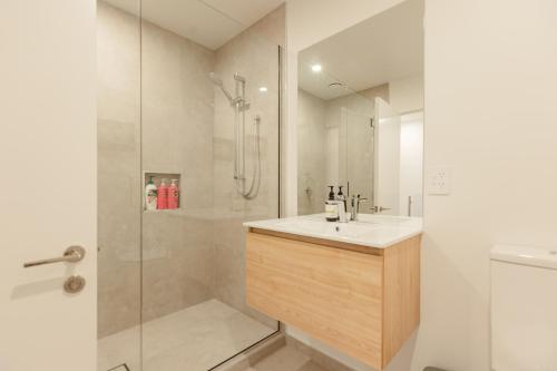 een badkamer met douche, wastafel en toilet bij Luxury CBD 2Bed2Bath With Parking Near Parks in Christchurch