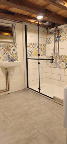 Cette chambre dispose d'une douche avec une porte en verre. dans l'établissement A little traditional French house, à Luchon