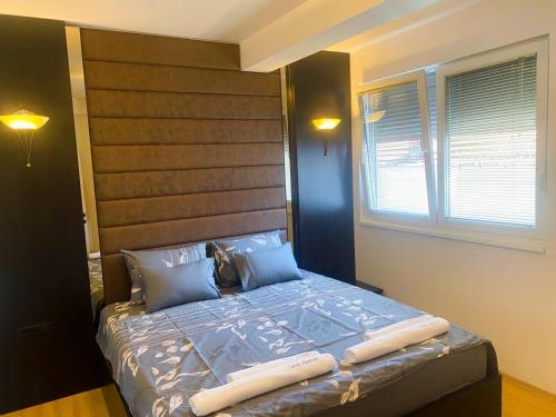 a bedroom with a large bed with a wooden headboard at Ohrid Central Apartment - FREE Private Parking in Ohrid