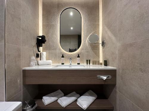 a bathroom with a sink and a mirror at Hotel Gladbeck van der Valk in Gladbeck