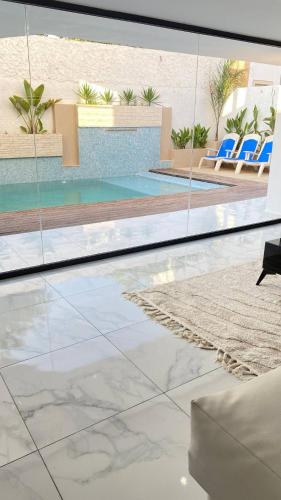Una vista de una piscina desde el interior de una casa. en Réf K200 Piscine, en Kelibia