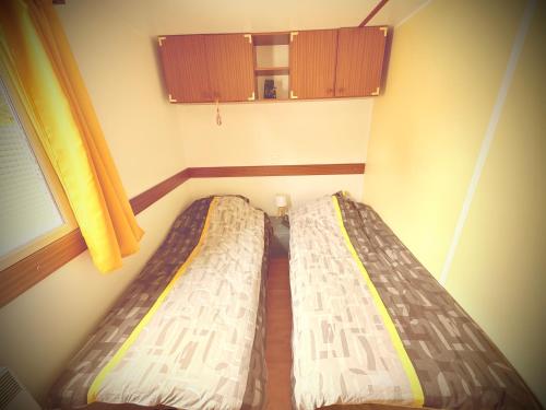 Ένα ή περισσότερα κρεβάτια σε δωμάτιο στο Mobile home tout confort à Carcans