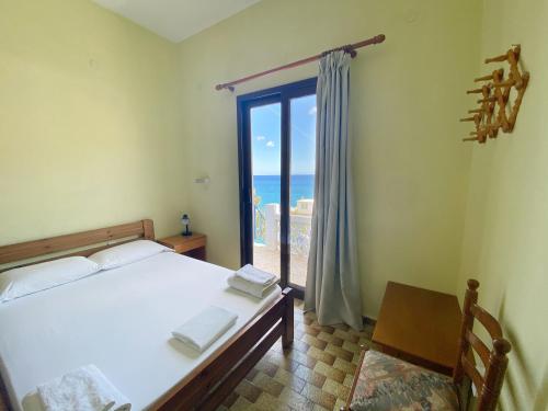 ディアファニにあるStudio Apartment Sea View with Balconyのベッドがあり海が見える寝室