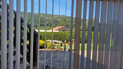 a white fence with a view of a house at Le Domaine de la Répandise in Laveline-du-Houx