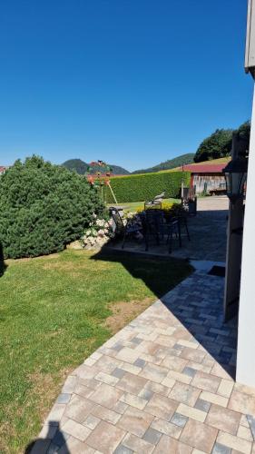 a patio with a table and chairs on the grass at Le Domaine de la Répandise in Laveline-du-Houx